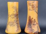 une paire de vases jaunes ornés d'une peinture représentant une maison et des arbres