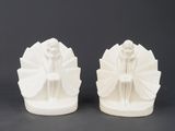 two white ceramic figurines of a woman and a man