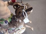 a figurine of a goat holding a wine glass