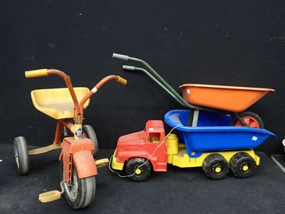 un tricycle pour enfant à côté d'un camion jouet et d'un tricycle pour enfant