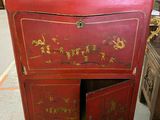 une vieille armoire rouge ornée d'inscriptions en chinois, dans un entrepôt