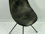 une image représentant une chaise noire dans une pièce blanche