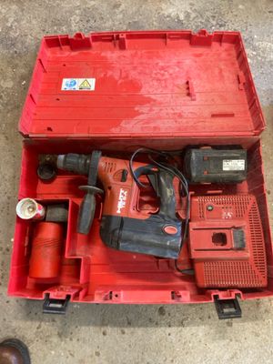 une boîte à outils rouge contenant une perceuse et un marteau