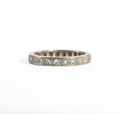 a close up of a diamond ring on a white surface