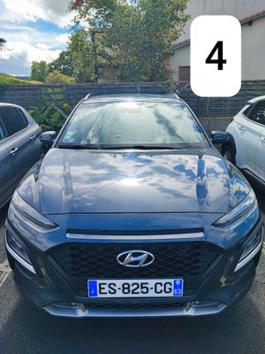 une voiture bleue garée dans un parking à côté d'autres voitures