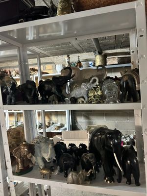 une étagère remplie de figurines d'éléphants de toutes sortes