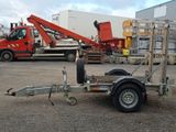 a trailer with a crane attached to it in a parking lot