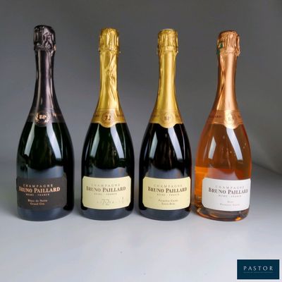 four bottles of champagne are lined up on a table