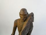 statue représentant un homme tenant un morceau de bois dans la main droite