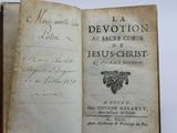 an old book with a hand holding it in it ' s left hand