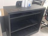 a desk with a book shelf in the corner of the room