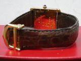 une montre posée sur une boîte rouge ornée d'une boucle dorée