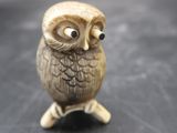 a small figurine of an owl sitting on a table