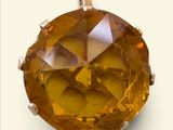 un gros plan d'un pendentif en diamant jaune sur fond blanc