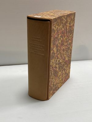 un vieux livre posé sur une table blanche à côté d'un mur blanc
