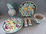 une table sur laquelle se trouvent une assiette, un bol, un vase et d'autres objets