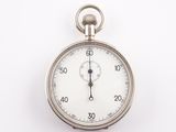 a close up of a silver pocket watch on a white surface