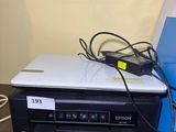 a laptop computer sitting on top of a printer