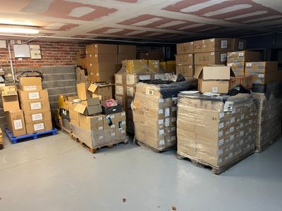 de nombreux cartons empilés sur des palettes dans le garage