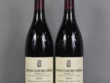 two bottles of wine sitting on top of a table next to each other