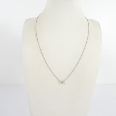 un torse de mannequin blanc orné d'une chaîne en argent et d'un pendentif en diamant