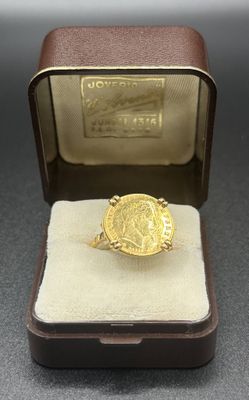 an image of a gold ring with a coin in a box