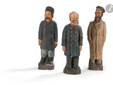trois figurines en bois représentant trois hommes barbus et coiffés d'un chapeau