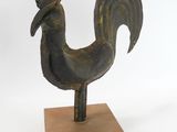 statue of a rooster on a wooden base on a white background