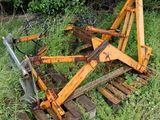 un tracteur qui est garé dans l'herbe, près d'une clôture