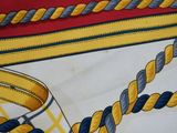 a close up of a yellow and blue tie on a red and white shirt