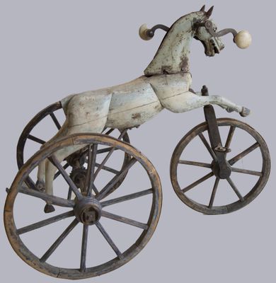 statue représentant un cheval tirant une charrette à roues, avec une balle dans la bouche