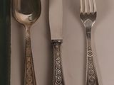three spoons, a fork, and a knife on a table