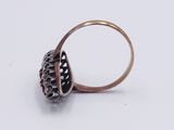a close up of a ring with a red stone in it