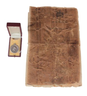 un bout de papier dans lequel se trouve une médaille d'or