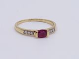 a yellow gold ring with a ruby stone and diamonds