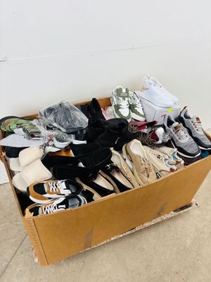 a cardboard box full of shoes on the floor