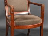 an old wooden chair with a tan upholstered seat