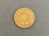 a close up of a gold coin on a gray surface