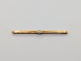 a close up of a gold bar with a pearl on it