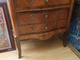 une commode avec un plateau en marbre sur lequel est posé un vase