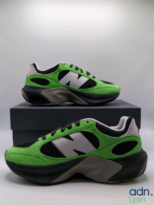 a pair of green and black sneakers sitting on top of a box