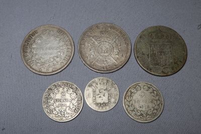 a group of five silver coins sitting on top of a table