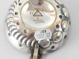 an image of a silver plate with a tag on it