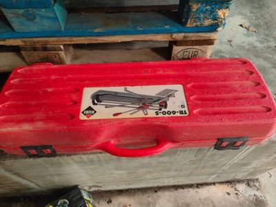 une mallette rouge avec un autocollant, posée sur une palette