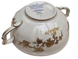 a white bowl with a gold decoration on it