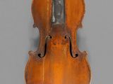an old violin with a bow hanging on a wall