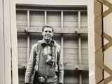 a black and white photo of a man standing in front of a building