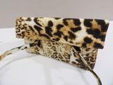 a close up of a leopard print purse on a white table