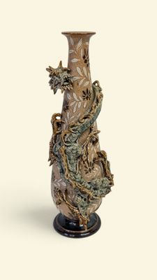 a vase with a dragon on it sitting on a stand