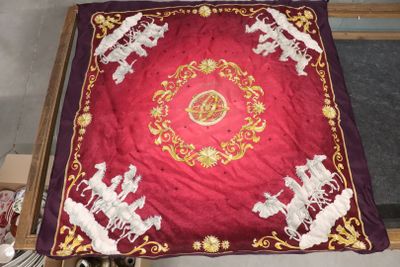 une table recouverte d'une nappe rouge sur laquelle sont représentés des animaux blancs